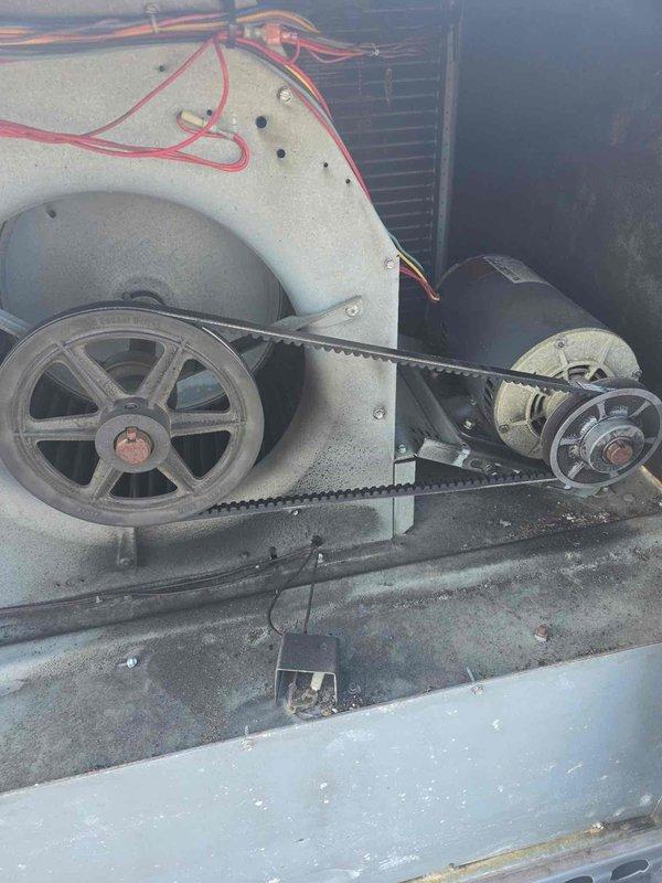 Performed diagnostic inspection of HVAC system and identified cracked fan belt requiring immediate replacement to prevent system failure. Documented existing conditions including belt-driven pulley assembly showing normal wear and operational air filter array in housing. Repair was approved and scheduled for completion during designated service window to restore unit to full operational capacity.