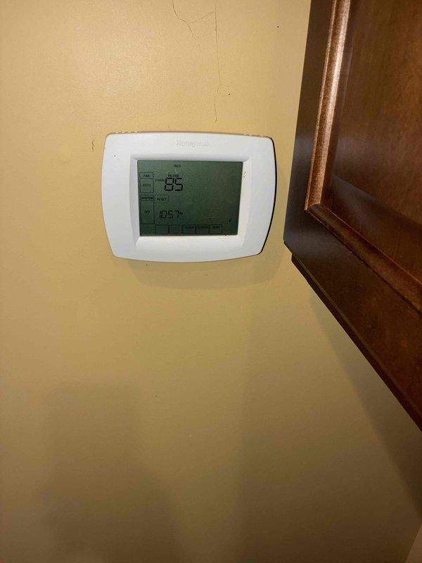 Completed comprehensive cooling and heating maintenance service on residential HVAC system. Inspected exterior condensing unit with protective cage enclosure and electrical junction box, verified proper operation and connections. Evaluated interior thermostat displaying 86°F setpoint with 83.7°F ambient temperature reading, confirmed proper calibration and functionality of digital control system.