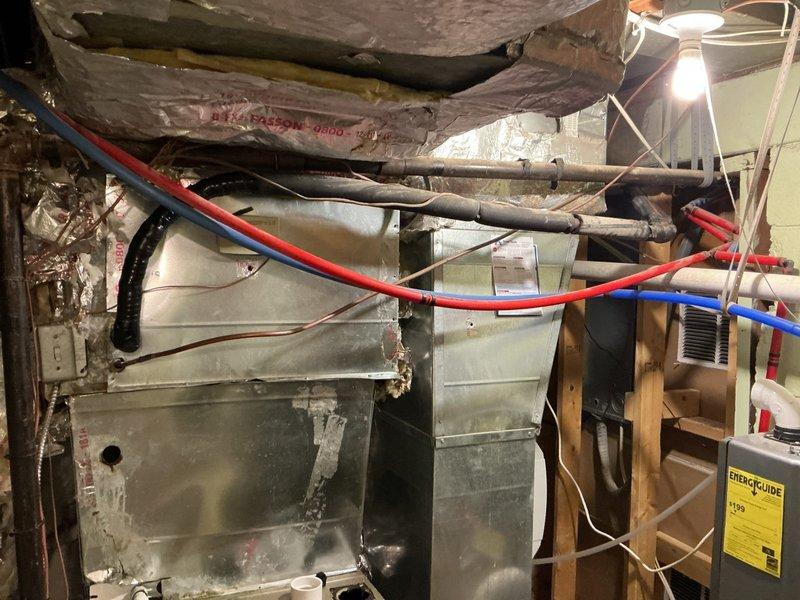 # HVAC Service - No Cool 10+ Years Old

Responded to after-hours no cooling call for aging HVAC system. Upon arrival, conducted comprehensive diagnostic evaluation of air handler unit located in attic space and associated ductwork system in basement utility area. System displayed signs of age-related wear with visible discoloration on metal surfaces and components showing extended service life beyond typical replacement intervals.

Performed systematic troubleshooting protocol including electrical testing, refrigerant line inspection, and airflow verification. Examined red and blue refrigerant lines for proper insulation and connection integrity. Inspected air handler unit for operational deficiencies, checking blower motor function, capacitor performance, and electrical connections. Evaluated ductwork assembly for air leakage and proper sealing at connection points.

Assessed condensate drainage system including black flexible drain line for proper flow and potential blockages. Verifi