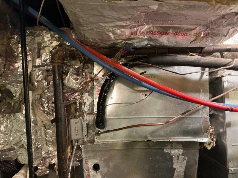 # HVAC Service - No Cool 10+ Years Old

Responded to after-hours no cooling call for aging HVAC system. Upon arrival, conducted comprehensive diagnostic evaluation of air handler unit located in attic space and associated ductwork system in basement utility area. System displayed signs of age-related wear with visible discoloration on metal surfaces and components showing extended service life beyond typical replacement intervals.

Performed systematic troubleshooting protocol including electrical testing, refrigerant line inspection, and airflow verification. Examined red and blue refrigerant lines for proper insulation and connection integrity. Inspected air handler unit for operational deficiencies, checking blower motor function, capacitor performance, and electrical connections. Evaluated ductwork assembly for air leakage and proper sealing at connection points.

Assessed condensate drainage system including black flexible drain line for proper flow and potential blockages. Verifi
