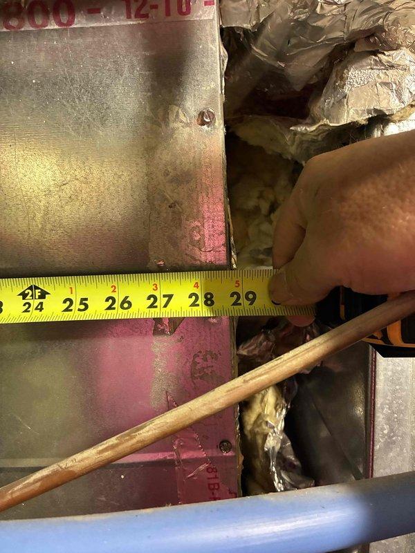 Responded to after-hours no cooling call for system evaluation and replacement estimate. Upon arrival, assessed existing outdoor condensing unit and indoor air handler installation. Took detailed measurements of existing ductwork and clearances in mechanical space, measuring between 25-29 inches to verify compatibility for new equipment installation. Documented current system configuration including refrigerant line routing, electrical disconnect location, and unit placement on concrete pad adjacent to brick exterior wall. Evaluated existing infrastructure including flexible ductwork connections and copper refrigerant lines. Provided comprehensive replacement estimate for complete HVAC system upgrade to restore cooling functionality to the residence.