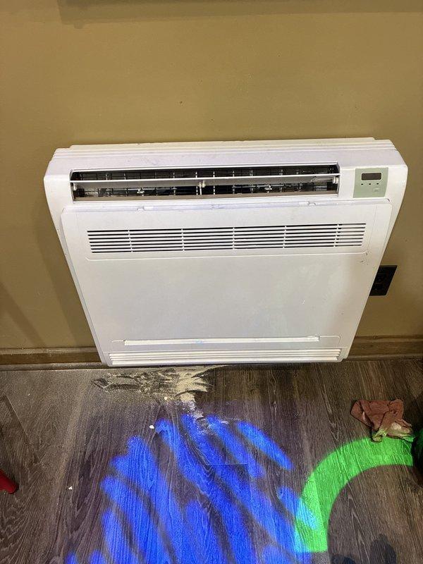 Completed installation of Carrier multizone ductless heat pump system consisting of one 37MGRAQ18CA3 Preferred Series inverter-driven outdoor condensing unit paired with two Performance Series floor console indoor units (45MBFAQ09XA3 and 45MBFAQ12XA3). Outdoor condenser was mounted on composite platform with proper elevation and positioned against exterior brick wall with surrounding decorative rock base for drainage and stability. Indoor floor console units were installed and mounted to interior walls with refrigerant line sets properly sized, routed, and connected between outdoor and indoor components. System was evacuated, pressure tested for leaks, and charged with refrigerant per manufacturer specifications. All electrical connections completed including dedicated circuits for outdoor unit and individual indoor zones. Condensate drain lines installed and tested for proper drainage. System startup performed with verification of proper operation in both heating and cooling modes acr