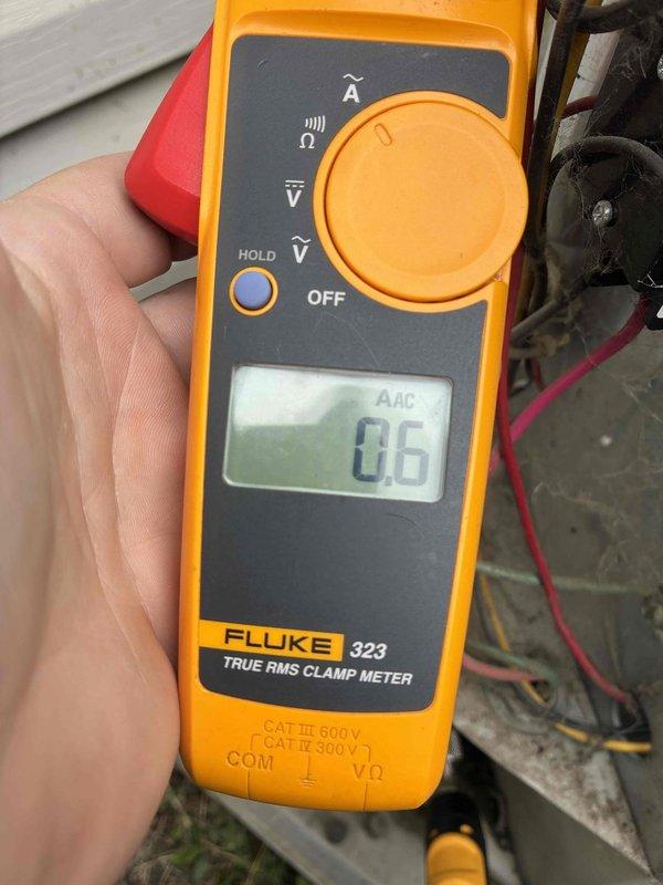 Responded to no cooling complaint with indoor temperature reaching 80s while system was running. Upon inspection, measured compressor amperage at 0.6 amps, indicating compressor failure to start or run properly under load. Normal operating amperage should read significantly higher (43 amps shown in subsequent testing suggests either capacitor replacement or compressor engaging after service). Diagnosed failed run capacitor or compressor issue preventing proper cooling cycle operation, resulting in inadequate temperature control and warm air distribution through supply vents.