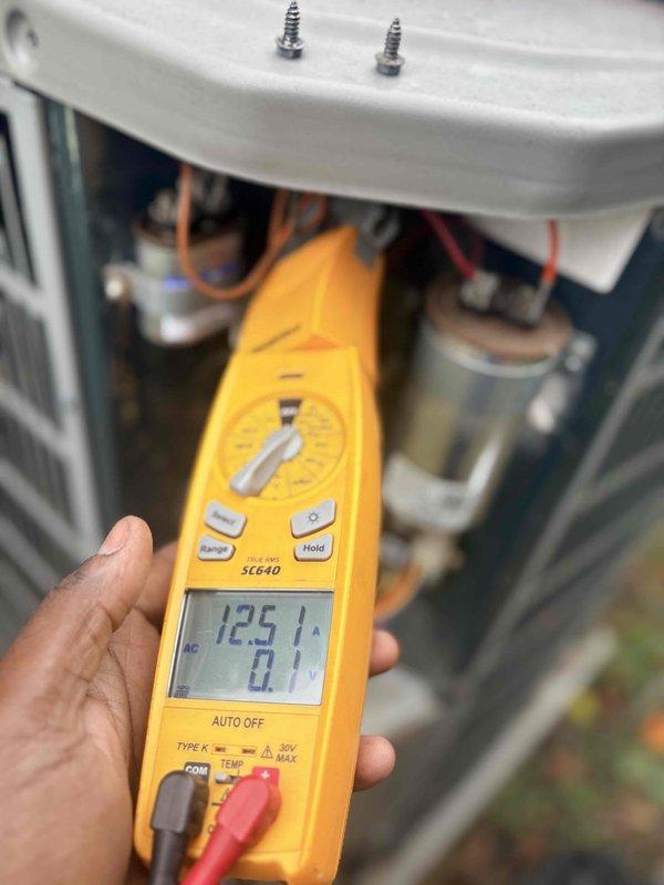 Performed comprehensive cooling system tune-up on residential outdoor condensing unit. Conducted electrical diagnostics using digital multimeter, measuring voltage at 125V and verifying proper electrical supply to unit components. Inspected and tested capacitor and electrical connections within the unit housing, ensuring all wiring terminations were secure. Measured system temperature at 195.3°F at the condensing unit, confirming proper refrigerant operation and heat rejection. Performed visual inspection of condenser fan assembly and protective guard, verifying proper mechanical condition and airflow. All electrical parameters tested within manufacturer specifications, and system operating efficiently with no deficiencies noted.