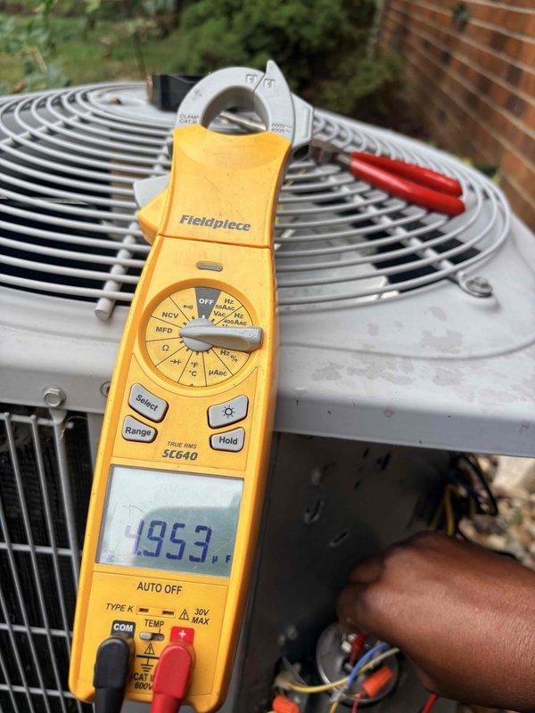 Performed comprehensive cooling system tune-up on residential outdoor condensing unit. Conducted electrical diagnostics using digital multimeter, measuring voltage at 125V and verifying proper electrical supply to unit components. Inspected and tested capacitor and electrical connections within the unit housing, ensuring all wiring terminations were secure. Measured system temperature at 195.3°F at the condensing unit, confirming proper refrigerant operation and heat rejection. Performed visual inspection of condenser fan assembly and protective guard, verifying proper mechanical condition and airflow. All electrical parameters tested within manufacturer specifications, and system operating efficiently with no deficiencies noted.