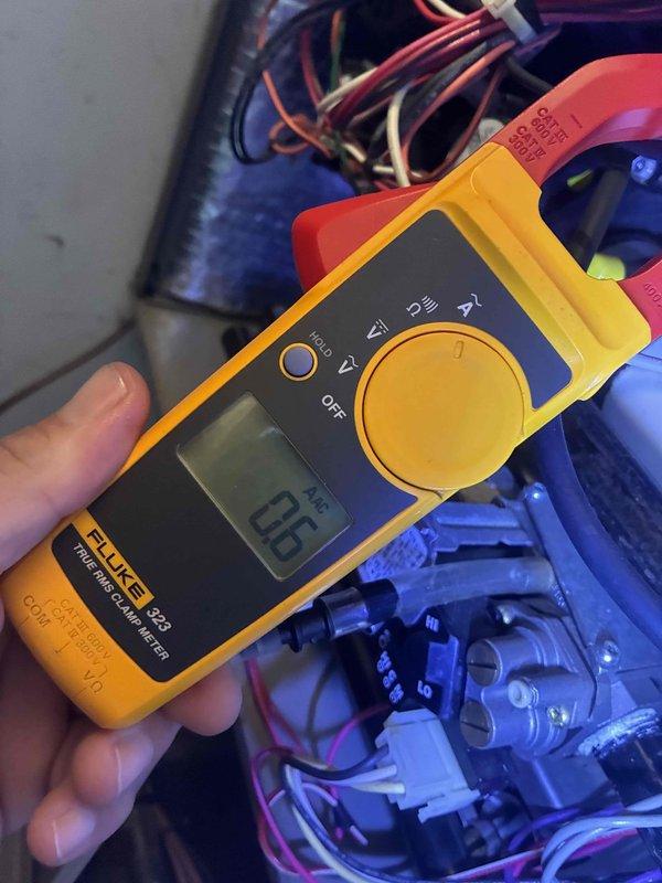 Completed scheduled heating maintenance on residential HVAC system. Performed comprehensive inspection of air handler unit, including examination of electrical components, control board, transformers, and wiring connections. Used Fluke 323 digital clamp meter to verify electrical current readings, which measured 0.6 amps during testing. Inspected all wire connections throughout the compartment, including bundled multi-colored wiring harnesses and individual circuit runs. Verified proper operation of dual transformer units mounted in upper compartment. All electrical connections found secure with no signs of overheating or deterioration. Control board functioning within normal parameters. System operational and ready for heating season.