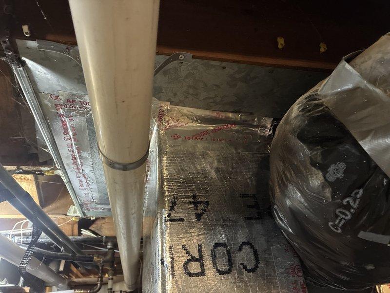 Returned to site to address previously identified return air ductwork issues. Inspected and photographed existing HVAC ductwork system in crawl space/attic area, including main supply trunk lines wrapped with Shurtape AF-100 reflective insulation, PVC condensate drain lines, and blower assembly. Completed necessary repairs and adjustments to return air plenum and associated ductwork to ensure proper system airflow and performance.