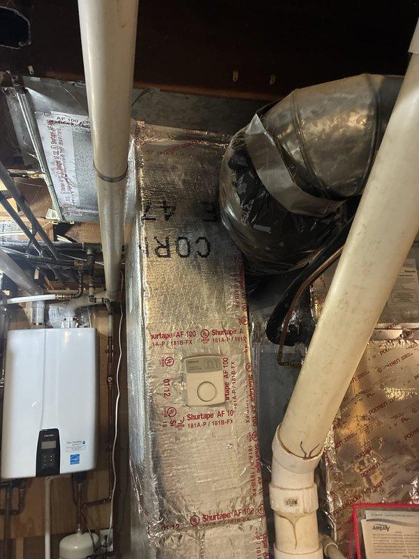 Returned to site to address previously identified return air ductwork issues. Inspected and photographed existing HVAC ductwork system in crawl space/attic area, including main supply trunk lines wrapped with Shurtape AF-100 reflective insulation, PVC condensate drain lines, and blower assembly. Completed necessary repairs and adjustments to return air plenum and associated ductwork to ensure proper system airflow and performance.