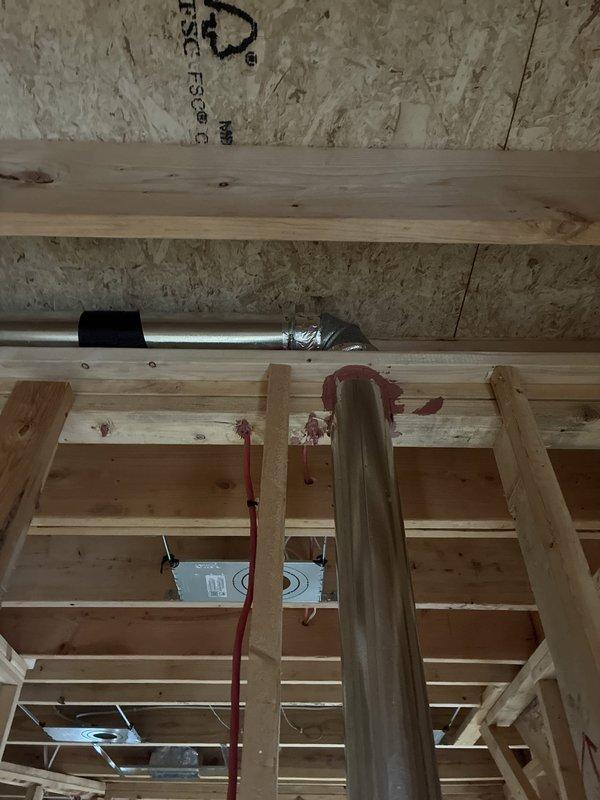 Completed installation of hose clamps on dryer vent ductwork and sealed all registers on the first floor to improve system efficiency and prevent air leakage. Work was performed in exposed framing areas with all components properly secured to structural members using appropriate mounting hardware and metal strapping.