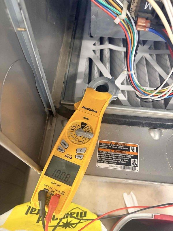 Completed comprehensive furnace tune-up including full system diagnostics and performance verification. Performed electrical testing with multimeter confirming proper voltage readings, inspected and verified control wiring connections with proper bundling and organization, and examined blower motor assembly and wheel for proper operation. All safety labels intact, system components operating within normal parameters, and unit found in good working condition with no immediate repairs required.