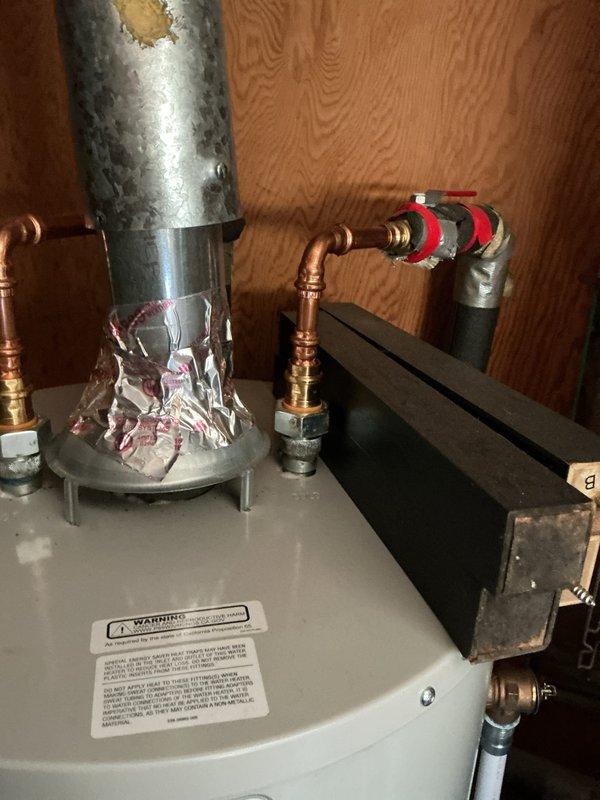 Responded to callback for water heater installed in December 2024 with reported temperature and pressure relief valve leak. Inspected Bradford White water heater installation including all copper supply line connections, expansion tank, and flue venting system. Documented condition of TPR valve, piping connections, and overall unit installation with photos showing top-mounted relief valve assembly and complete plumbing configuration.