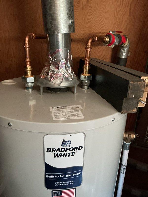Responded to callback for water heater installed in December 2024 with reported temperature and pressure relief valve leak. Inspected Bradford White water heater installation including all copper supply line connections, expansion tank, and flue venting system. Documented condition of TPR valve, piping connections, and overall unit installation with photos showing top-mounted relief valve assembly and complete plumbing configuration.
