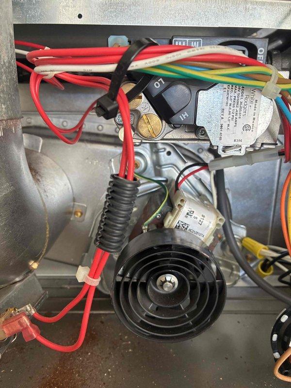 Responded to service call for two-year-old furnace making unusual noises. Performed diagnostic inspection of unit, examining blower motor assembly, electrical connections, control modules, and gas valve components. Documented internal system components with photographs showing wiring harness, safety controls, and mechanical assemblies all appearing intact and properly secured.