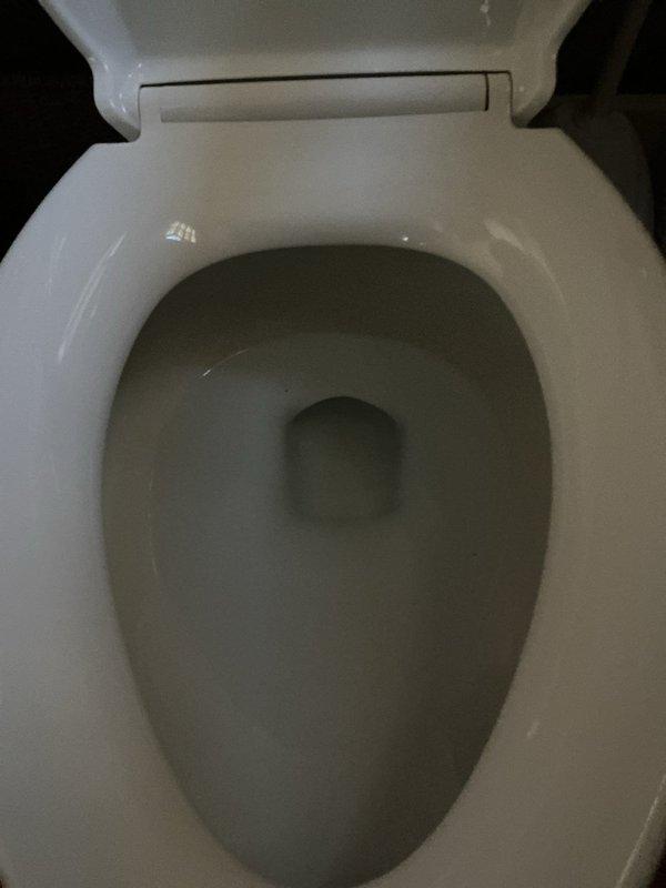 Completed installation of standard two-piece white porcelain toilet in bathroom corner location. Connected water supply line to tank, secured unit to floor flange, and verified proper flush operation and bowl refill. Toilet is fully operational with no leaks detected at supply connection or base seal.