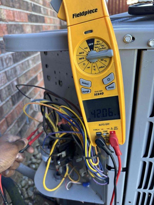 Performed late season air conditioning maintenance and cleaning. Inspected blower assembly and verified fan wheel condition, finding all blades intact with no debris accumulation. Measured capacitance at 28.6 MFD using digital multimeter and verified electrical connections at control panel, confirming all wiring secure and system operating within normal parameters.