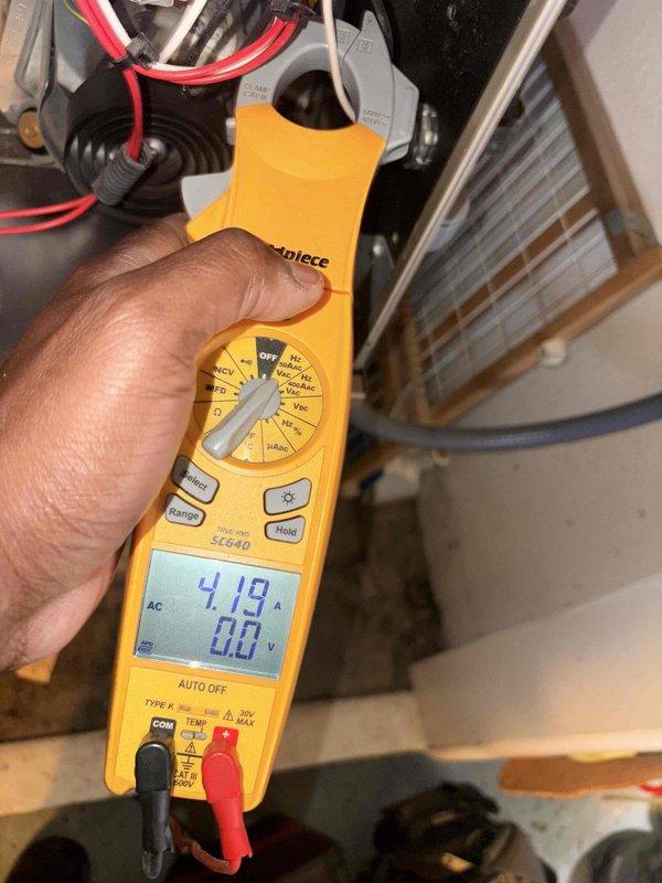 Completed preventative maintenance on heating system. Performed electrical diagnostics using clamp meter on outdoor unit wiring, recording voltage and amperage readings of 62.9V and 0.0A on multi-conductor bundle. Tested indoor air handler electrical system, measuring 4.13A current draw with 0.0V secondary reading. Inspected heat exchanger coil and verified all electrical connections secure. System operating within normal parameters.