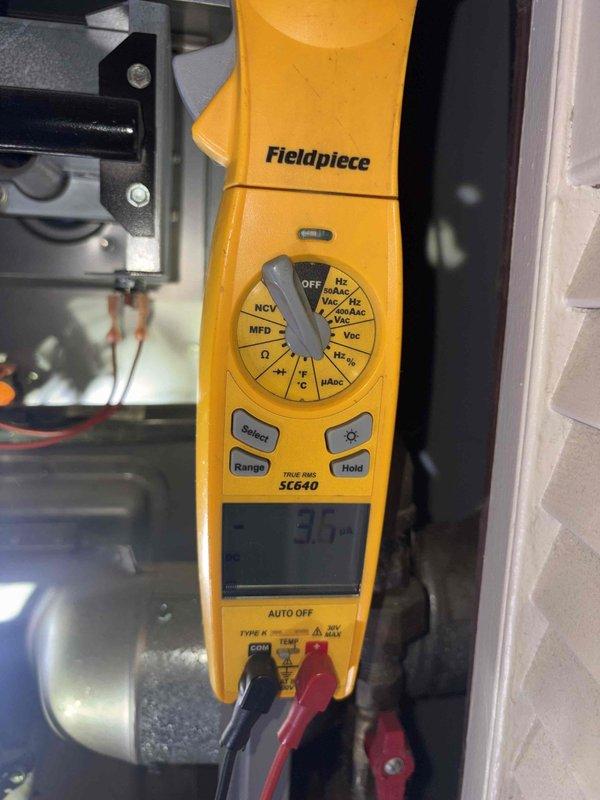 Performed a furnace tune-up with the access panel removed, inspecting the burner assembly, heat exchanger openings, gas valve and manifold, inducer motor, flue elbow, pressure switch, and wiring harnesses. Checked electrical operation with a clamp meter and found no visible damage, rust, or cracks, with only light dust and debris in the cabinet.