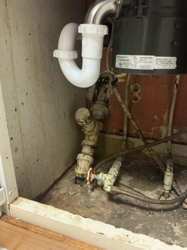 Diagnosed and cleared clogged kitchen sink drain line where disposal was backing up into sink when activated. Discovered significant mineral buildup and corrosion in older metal pipes connected to the P-trap. Recommended hydro-jetting service to address severe blockage and prevent recurrence.