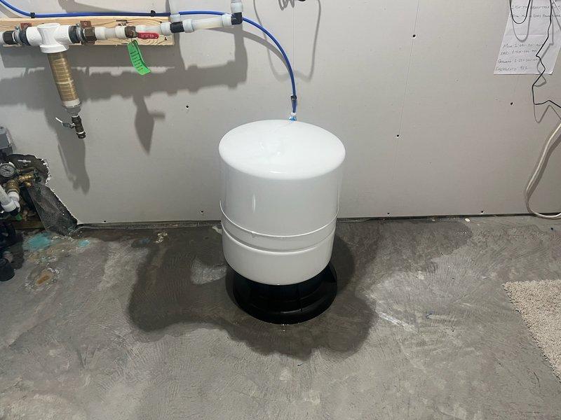 Diagnosed and repaired a leak on previously installed 8-12 R/O system where customer reported water on floor around unit and no water production. Inspection revealed the RO storage tank was leaking due to a split 3/4" plastic 90-degree fitting. Replaced the damaged plastic fitting with a more durable brass 90-degree fitting to resolve the issue and restore proper system operation.