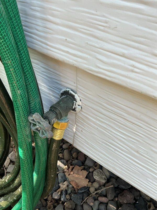 Inspected property for reported water leak at washer hookups. Identified multiple leaking gate valves requiring immediate attention. Conducted diagnostic assessment of equipment room plumbing system and documented deteriorated exterior plumbing connections including weathered pipe assembly and improperly sealed wall penetration. Recommended comprehensive equipment room repipe to address systemic valve failures and prevent future leaks.