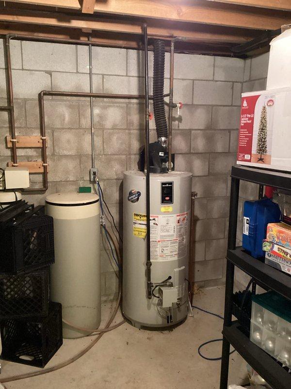 Diagnosed and replaced failed inducer blower fan motor on Bradford-White water heater that was creating excessive noise. Observed significant copper pipe corrosion with visible green patina and mineral buildup around valve connections. System now operating normally with proper ventilation restored.