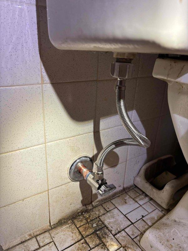 Responded to service call for malfunctioning water shut-off valve in master bathroom. Diagnosed broken angle stop on toilet where handle had separated and valve was not fully closing. Replaced defective angle stop valve and installed new stainless steel braided supply line to restore proper water flow control to toilet.