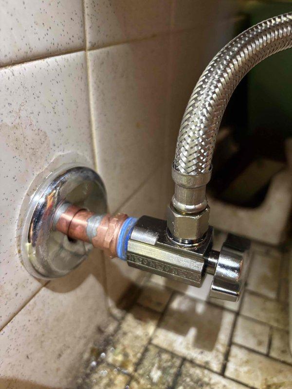 Responded to service call for malfunctioning water shut-off valve in master bathroom. Diagnosed broken angle stop on toilet where handle had separated and valve was not fully closing. Replaced defective angle stop valve and installed new stainless steel braided supply line to restore proper water flow control to toilet.