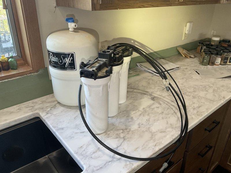 Completed comprehensive kitchen plumbing overhaul including installation of customer-supplied kitchen faucet and garbage disposal, replacement of under-sink plumbing components, and reinstallation of RO filtration system with connections to refrigerator and integrated kitchen faucet. All fixtures properly connected, tested, and functioning according to manufacturer specifications.