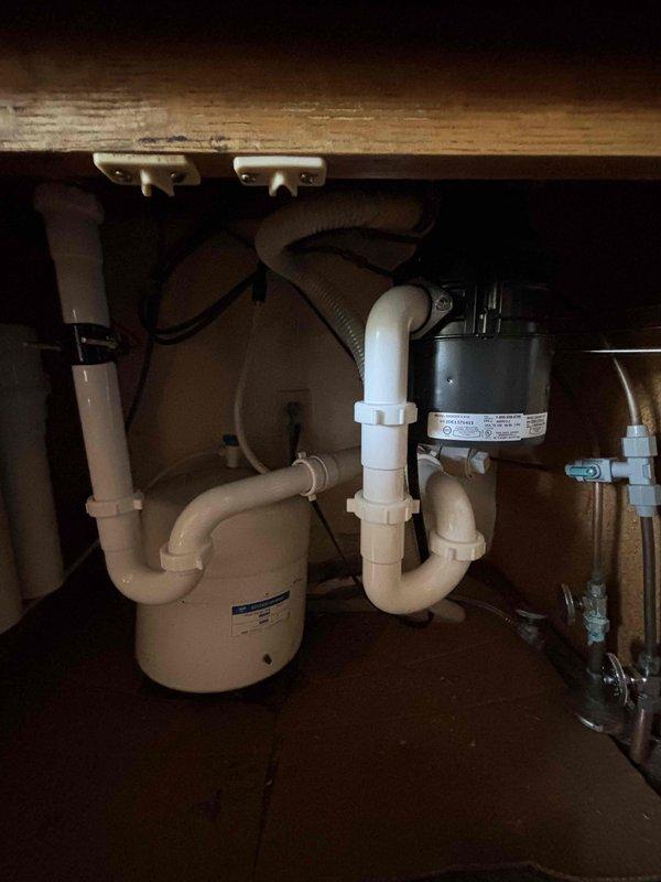 Returned to customer's residence to reposition towel bar in kitchen sink cabinet that was inadvertently placed behind garbage disposal during previous installation. Successfully removed and reinstalled towel bar in front of disposal unit to restore proper functionality and access.