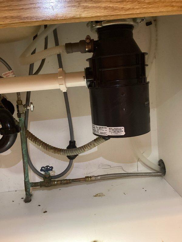 Removed and replaced a rusted garbage disposal that was jammed with coffee beans, which had caused sink drainage failure and standing water in dishwasher. Completed system reconnection and verified proper drainage with no leaks detected after installation.