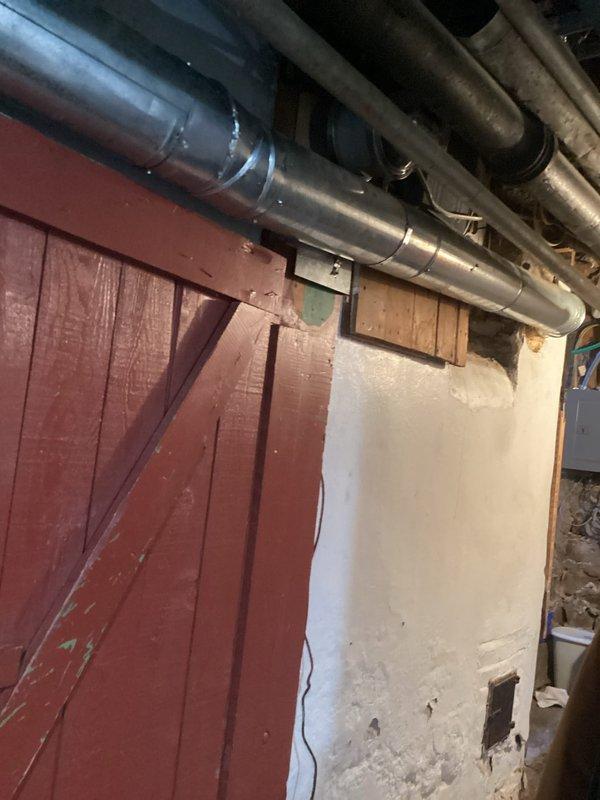 Performed routine maintenance on Crown oil boiler system including nozzle replacement and heat exchanger inspection. System is operating properly, however identified a code violation where vent pipe makes direct contact with wooden structure creating fire hazard. Recommended immediate correction of vent pipe clearance issue to bring installation into compliance with safety standards.