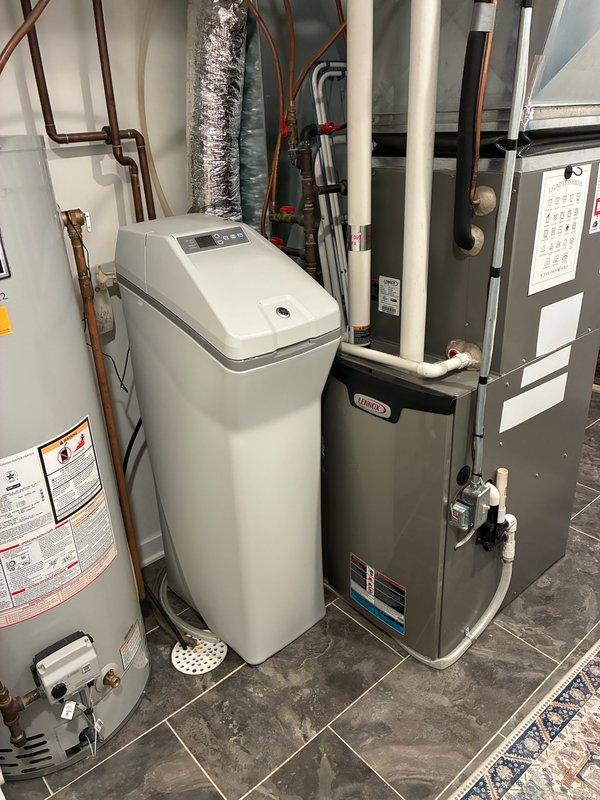 Performed diagnostic service on 8-year-old GE water softener that was failing to complete regeneration cycles properly. Found system overfilling with multiple leaks from the head unit and tested water at 25 grains of hardness, significantly exceeding acceptable levels. Due to extensive corrosion and risk of worsening leaks, placed unit in bypass mode and provided replacement options to customer.