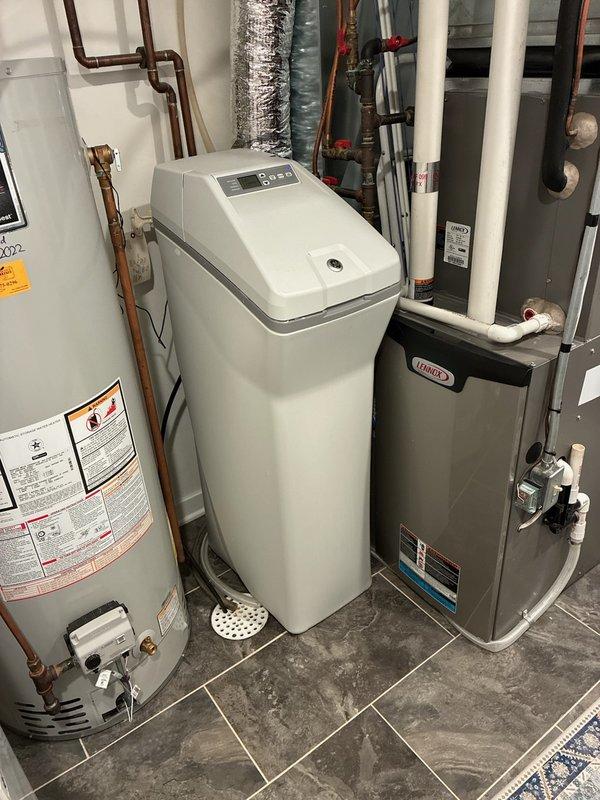 Performed diagnostic service on 8-year-old GE water softener that was failing to complete regeneration cycles properly. Found system overfilling with multiple leaks from the head unit and tested water at 25 grains of hardness, significantly exceeding acceptable levels. Due to extensive corrosion and risk of worsening leaks, placed unit in bypass mode and provided replacement options to customer.