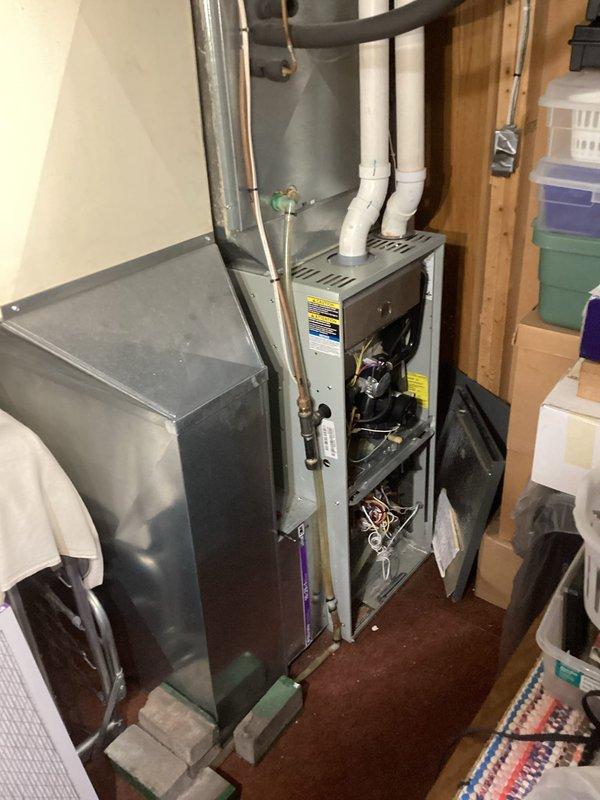 Performed routine LP furnace tune-up on 10-15 year old system. Inspection revealed critical safety issues including cracked heat exchanger with visible holes in side. Unit was tagged out of service due to safety concerns. Service advisor dispatched to discuss replacement options with customer.