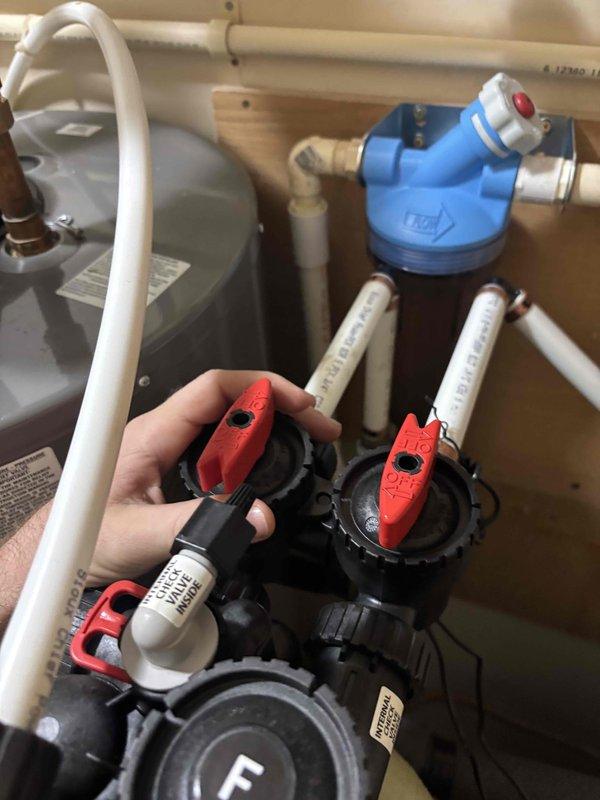 Responded to customer complaint of rusty water following recent water heater installation. Upon inspection, determined the water treatment system was inadvertently left in bypass mode. Adjusted valve positions to correctly route water through the filtration system, restoring normal operation.