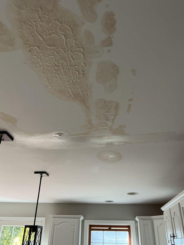 Inspected kitchen ceiling showing active water damage with visible staining and bubbling. Determined source was upstairs bathroom toilet with severely corroded flange and failing wax ring causing phantom leak. No active plumbing line breach found. Referred customer to water damage restoration company for ceiling repair.