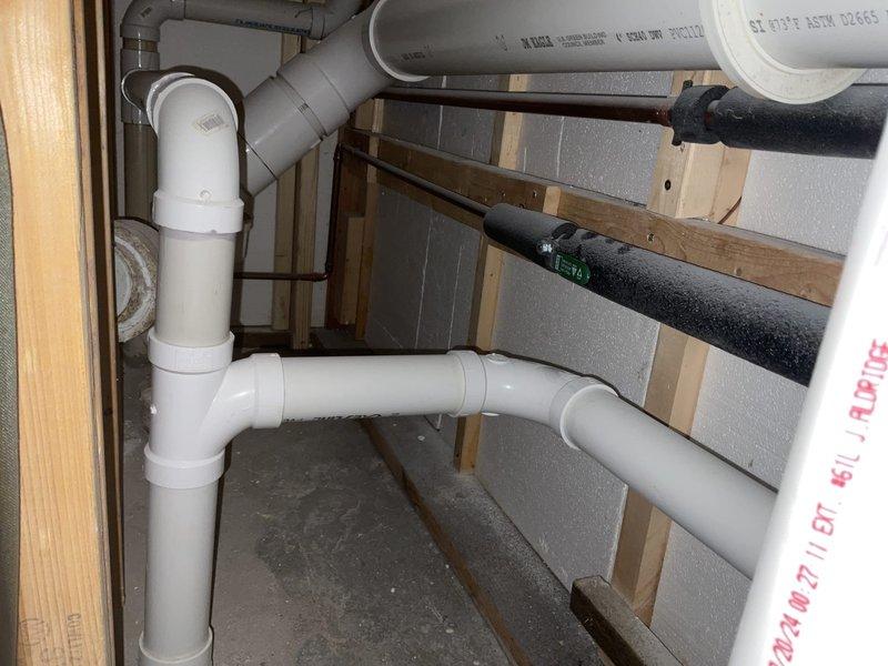 Investigated sewer gas odor in recently remodeled basement bathroom. Diagnostics revealed floor drain backup and gurgling when draining bathroom sink and utility sink. Installed 2" PVC wye with cleanout access and cleaned drain piping to eliminate cross-contamination and prevent sewer gas infiltration.