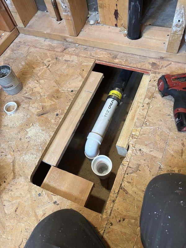 Completed installation of customer shower pan with mortar mix, installed shower valve, and performed rough-in plumbing work for the shower assembly. Work included cutting access to existing plumbing, mounting valve fixture with copper pipe connections, and preparing the floor for proper shower pan installation.
