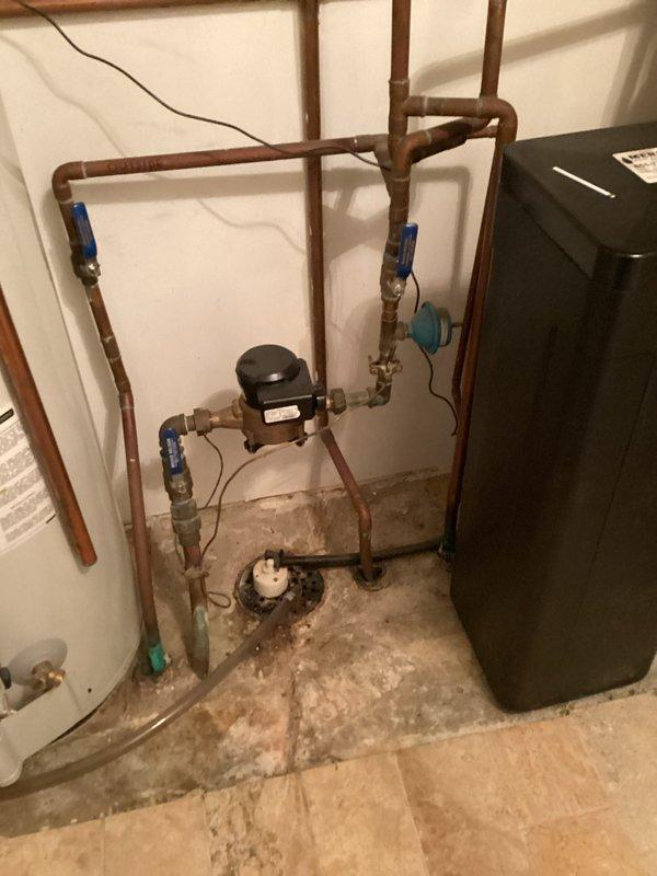 Performed comprehensive inspection on 10-15 year old tanked water heater located in compact utility closet. System includes copper plumbing network with circulation pump and multiple valve connections. Provided client with maintenance recommendations and replacement estimates due to unit's advanced age, though no immediate operational issues were identified.