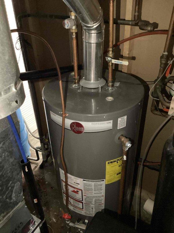 Responded to emergency call for water heater leak. Discovered water spraying from side of Rheem Professional tanked water heater. Diagnosed failure point, shut off gas and water supply to prevent further damage. Provided customer with replacement quote after determining repair was not economical due to unit condition.