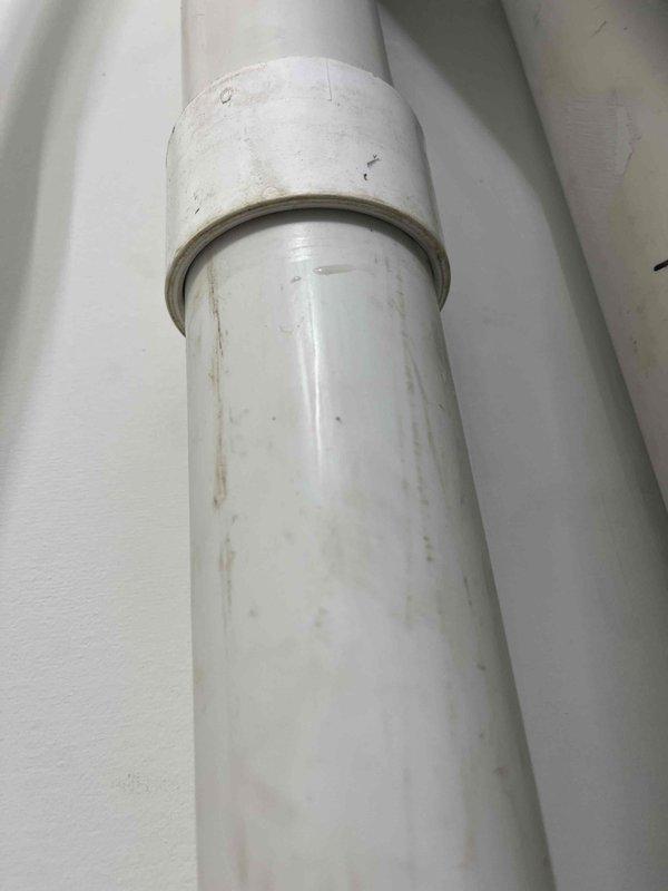 Responded to warranty service call for recently installed furnace exhibiting water leakage around exhaust pipe. Diagnosed insufficient glue at pipe coupling causing significant leakage that affected surrounding floor and gas pipe. Remediated by cutting out the defective section and replacing with new PVC pipe connection, resolving the moisture issue.