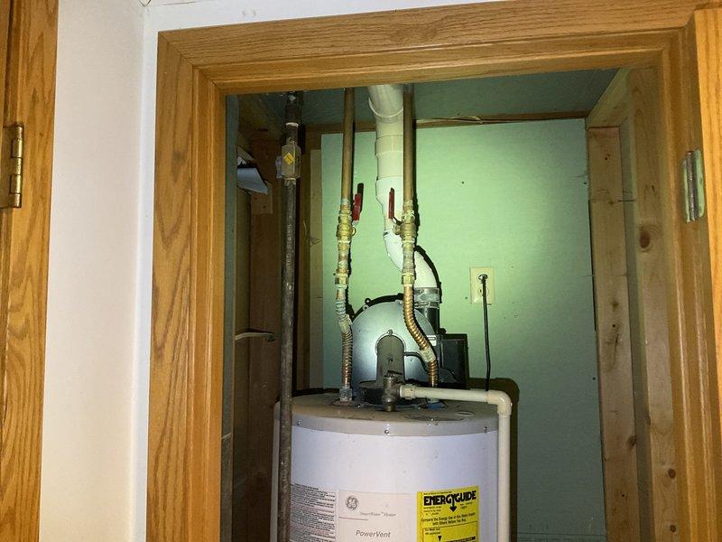 Responded to service call for water heater leak issue. Inspected 2004 model power vent water heater with active leak originating from top seal. Determined unit had a cracked tank with significant deterioration. Provided customer with replacement options for a new LP power vent water heater system.
