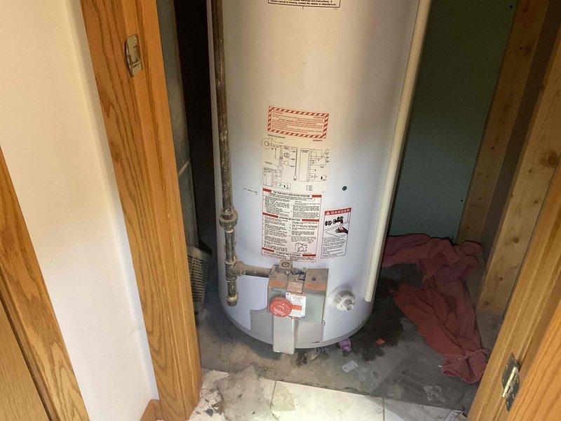 Responded to service call for water heater leak issue. Inspected 2004 model power vent water heater with active leak originating from top seal. Determined unit had a cracked tank with significant deterioration. Provided customer with replacement options for a new LP power vent water heater system.