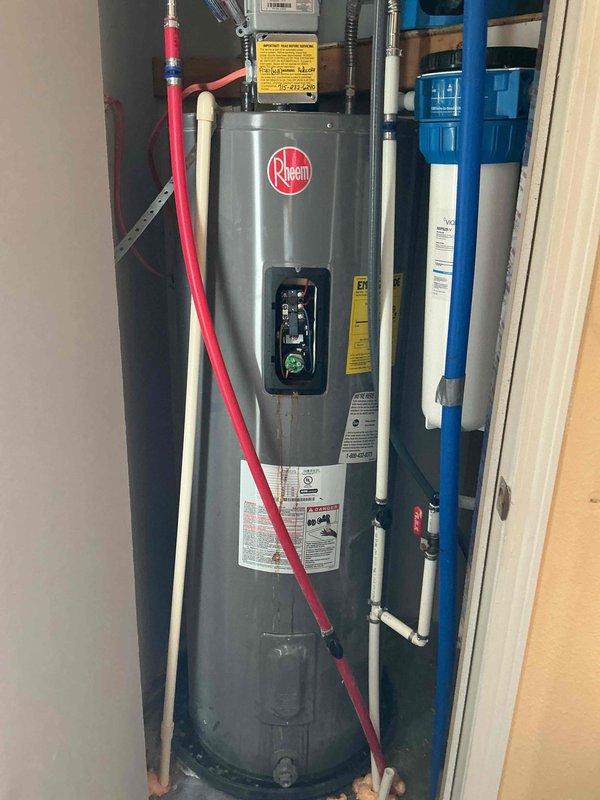 Diagnosed 5-year-old Rheem electric water heater with complete failure due to tank rupture. Recommended full replacement of unit as repair not feasible. Also noted customer request to replace whole home water filter (CF-155358-43); discussed replacement options but deferred installation pending customer financing approval.