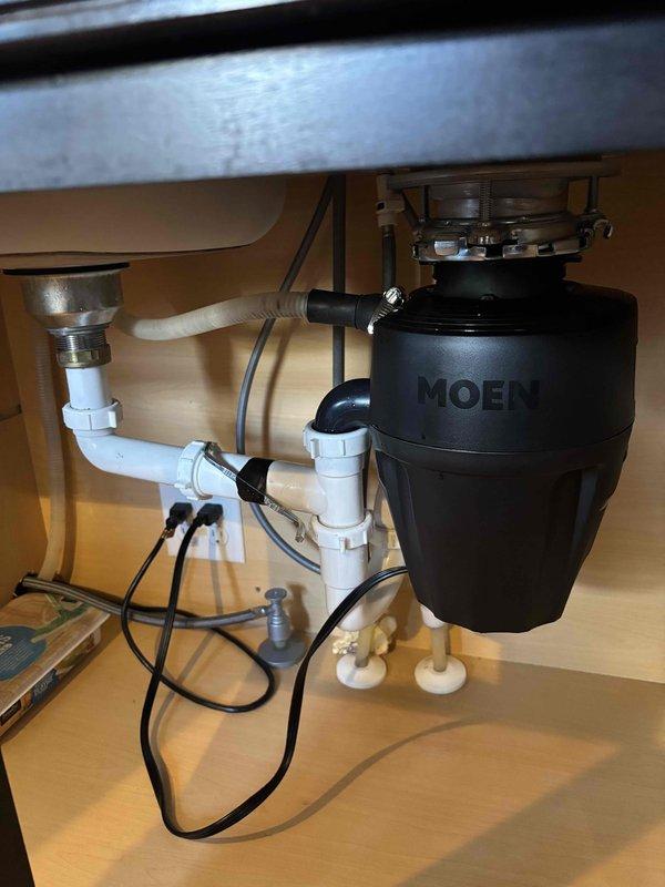 Successfully installed customer-supplied MOEN garbage disposal unit, correctly connecting it to the existing PVC drain pipe system with proper P-trap configuration. Ensured all connections were secure with no leaks present, and verified proper electrical connections for optimal functionality.