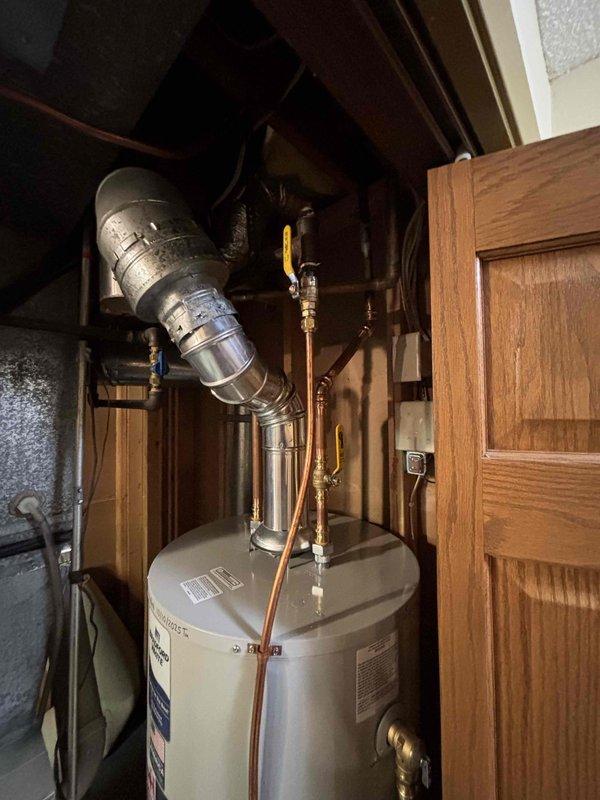Diagnosed water leak at base of 14-15 year old 50-gallon water heater. Determined tank was rusting out, causing leakage. Replaced aging water heater with new Bradford White unit, installed all necessary copper supply lines and ventilation components, and verified proper operation of the new system.