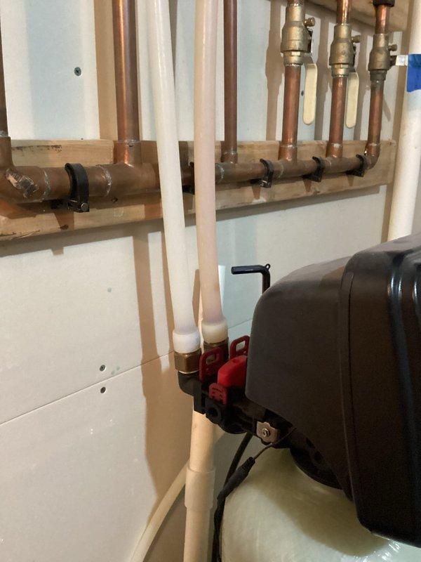 Diagnosed low water pressure issue occurring when multiple fixtures were in use simultaneously. Upon inspection, determined that the 11-year-old water softener was causing flow restriction. Bypassed the water softener to restore normal pressure and conducted water hardness testing, which revealed 11+ grains of hardness. Recommended replacement of the aging water softener system.