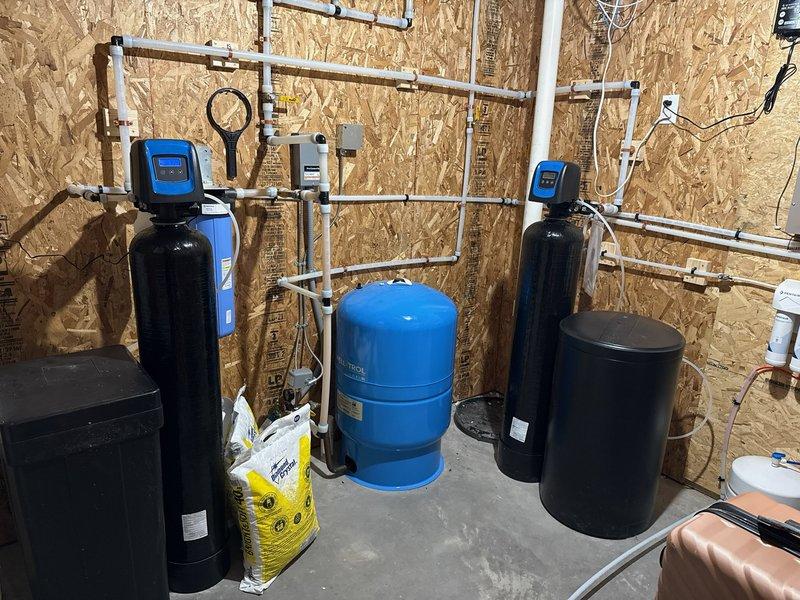 Diagnosed multiple issues with customer's water treatment system. Found softener had previously been stuck in backwash cycle with motherboard failure, while nitrate reduction system showed no salt consumption since installation, likely due to salt bridging in brine tank. Upon arrival, softener was functioning properly. Programmed both systems to regenerate overnight and advised customer to monitor salt usage and report if problems persist.