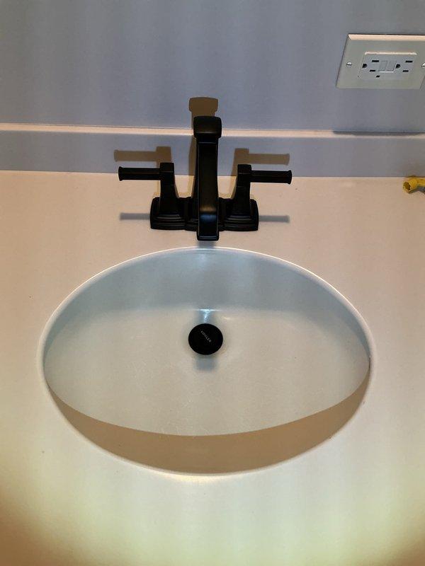 Completed 4-hour service call to install customer-supplied toilet and bathroom vanity faucet. Successfully installed new black matte finish widespread faucet on oval white sink. This was a return visit to complete previously started work.