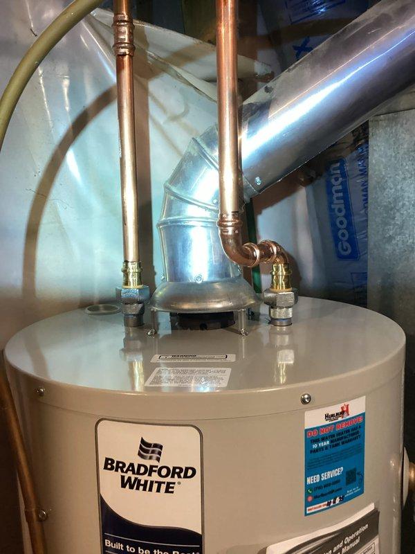 Installed new 40 gallon Bradford White atmospheric water heater in utility room with proper copper piping connections and ventilation system. Completed the installation provided by Hurlburt with all required fittings and ensured proper function of the unit.